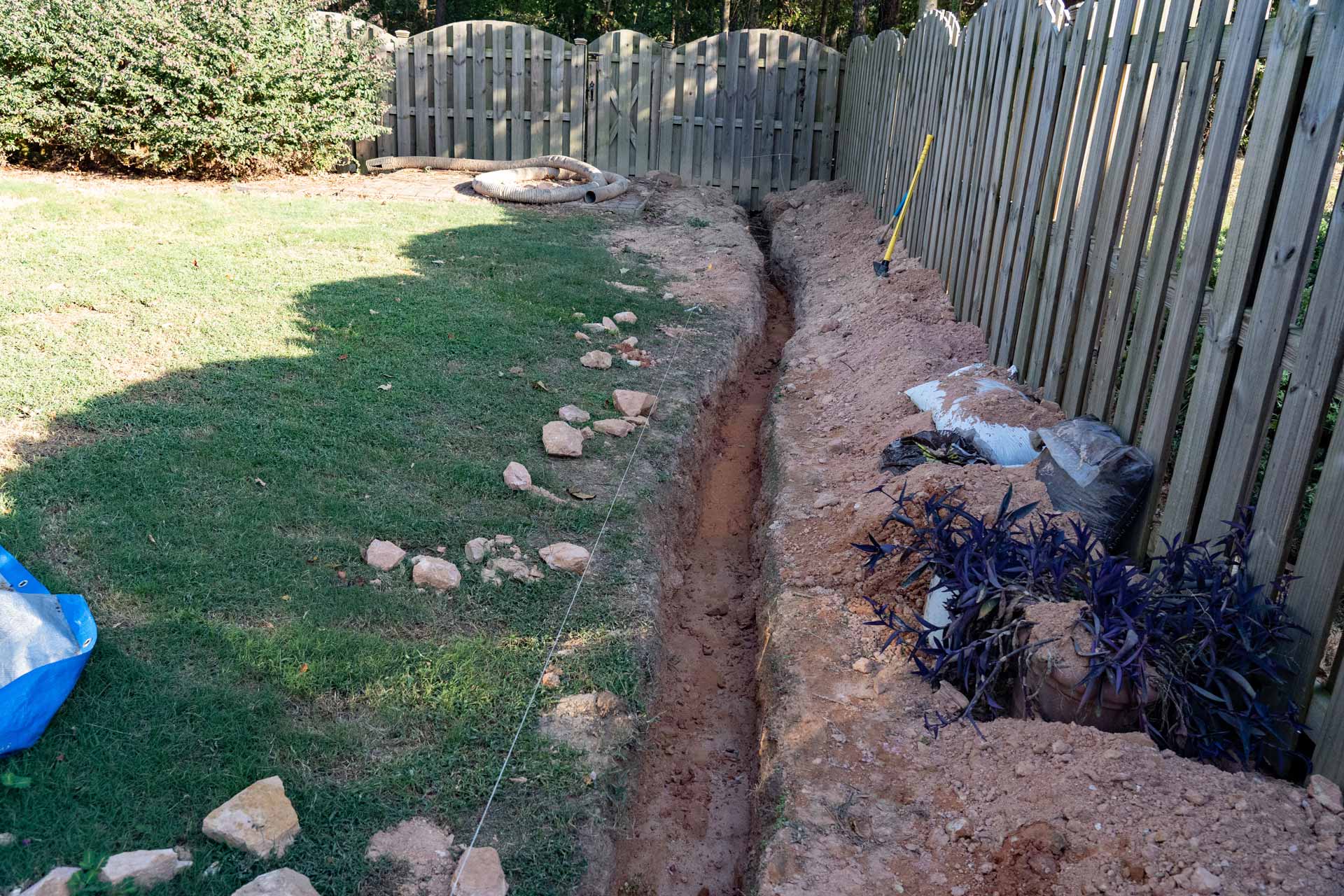 In-progress trench digging for French drain installation